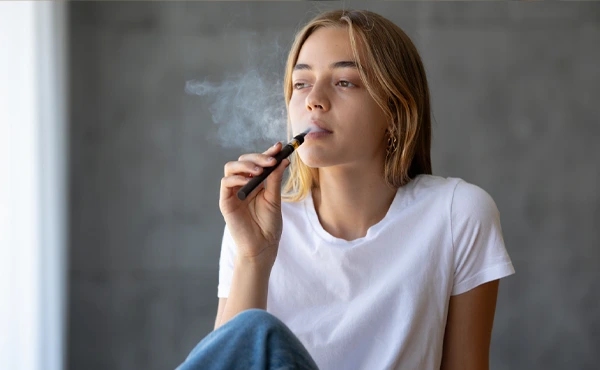 Зависимость от электронных сигарет Девушка курит электронную сигарету